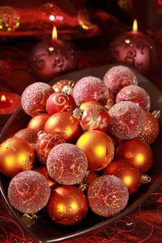 Detail of Christmas balls with candles in red tone