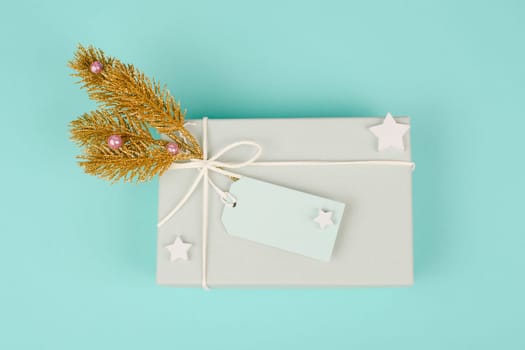 Gift box with a blank tag,golden fir branches, christmas holiday wintertime