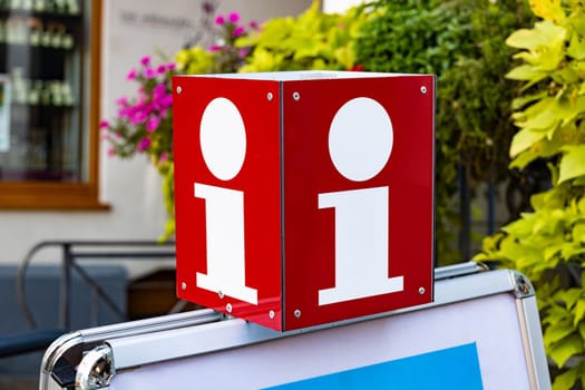 Red Information sign in front of a public touristic office downtown.
