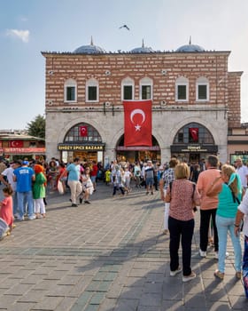 Istanbul, Turkey - August 30, 2022: Crowds of local citizens at Eminonu during the Victory Day holiday with entrance of The Spice Bazaar, aka Misir Carsisi, or Egyptian Bazaar in the background