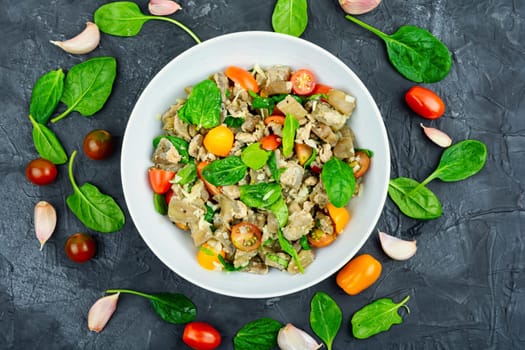 Tasty salad of baked eggplant, tomato and spinach.
