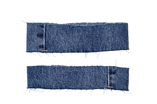 Pieces of jeans fabric with fringe isolated on white background. Two cut-off pant leg pieces of a blue denim jeans. Macro.
