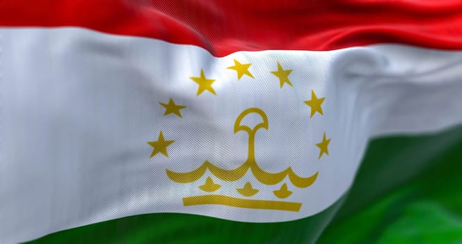 Close-up view of the Tajikistan national flag waving in the wind. The Republic of Tajikistan is a landlocked country in Central Asia. Fabric textured background. Selective focus. 3D illustration