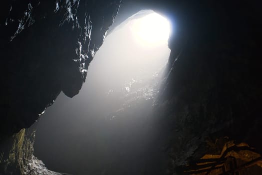 Rock cave with hole through which light shines. Underworlds in Sweden. Mystical atmosphere. Nature shot from Scandinavia