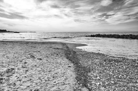 Stand in black and white taken in Denmark with stone downs . Stones, shells and seaweed on the coast. Landscape photo from sea