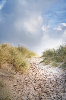Beach crossing in Denmark by the sea. Dunes, sand water and clouds on the coast. Trip to the Baltic Sea. Vacation on the beach. Scandinavia landscape photo