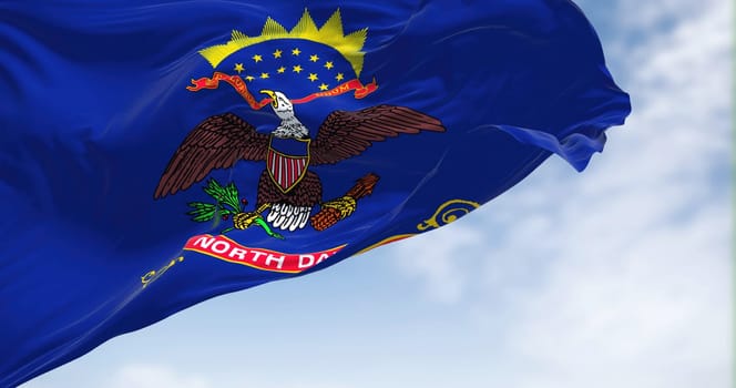 Close-up view of the North Dakota state flag waving on a clear day. Fabric textured background. US state flag. 3D illustration