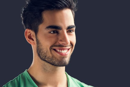 Portrait of handsome young man drinking coffee, isolated on gray background