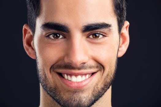 Portrait of handsome young man smiling, isolated on gray background