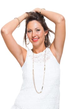 Portrait of a young brunette woman with her hands in her hair joyfully laughing isolated against a white background