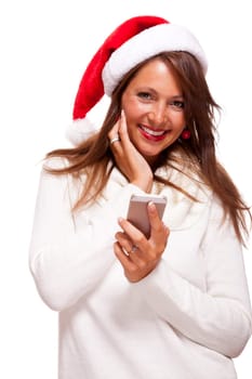 Attractive woman with red Santa hat reads a text message on her phone smartphone and sends Christmas wishes smiling with joy isolated on white with text-free free-space