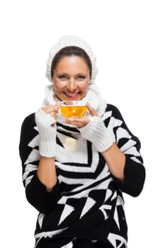 Young brunette woman with white wool lyane drinks a cup of tea to warm up isolated on white background