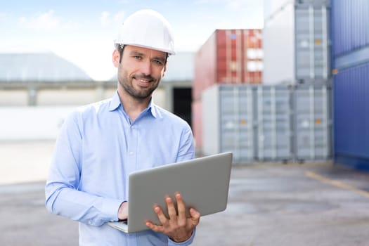 View of a Young Attractive engineer using laptop on the dock