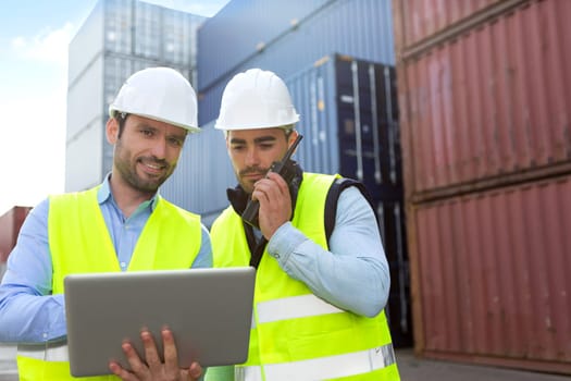 View of a Dock worker and supervisor checking containers data on tablet