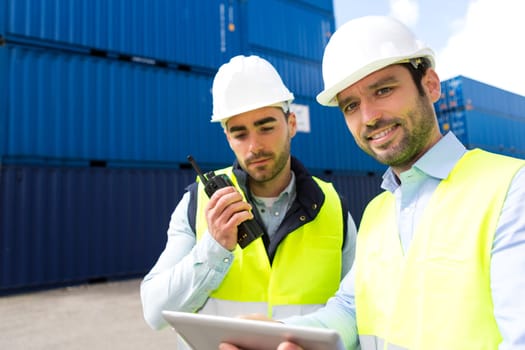 View of a Dock worker and supervisor checking containers data on tablet