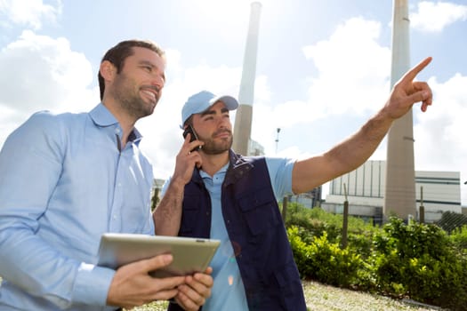 View of an Electrician and engineer working together at the electric station