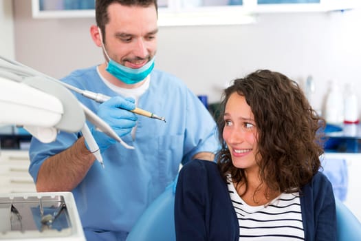 View of a Young attractive woman being cured by a dentist