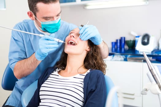 View of a Young attractive woman being cured by a dentist
