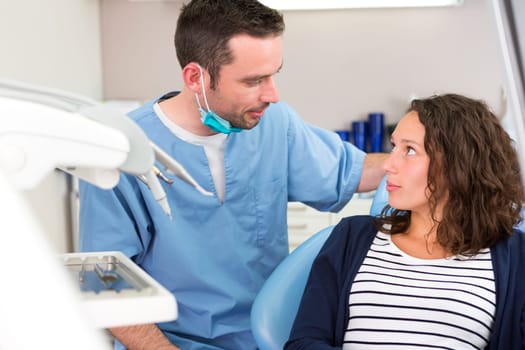 View of a Young attractive dentist explaning his work to a patient