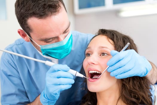 View of a Young attractive woman being cured by a dentist