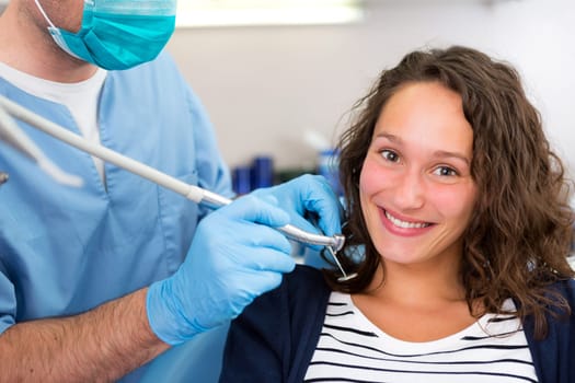 View of a Young attractive woman being cured by a dentist