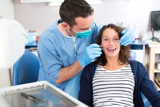 View of a Young attractive woman being cured by a dentist