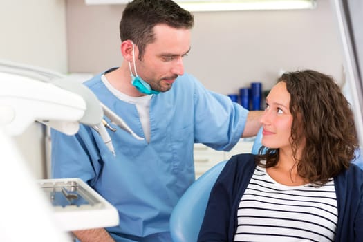 View of a Young attractive dentist explaning his work to a patient