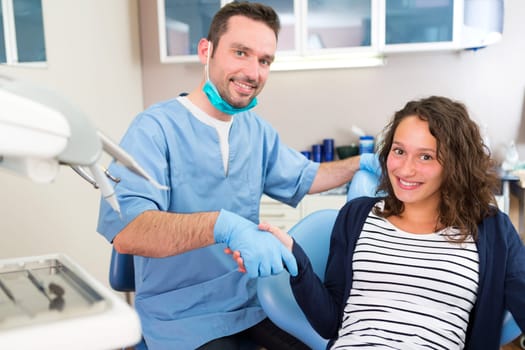 View of a Young attractive dentist explaning his work to a patient