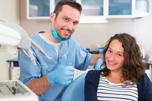 View of a Young attractive dentist explaning his work to a patient
