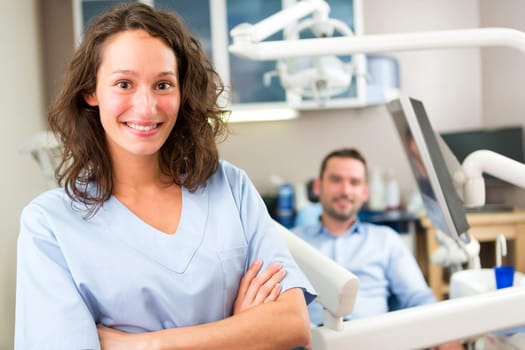 View of a young attractive dentist in his office