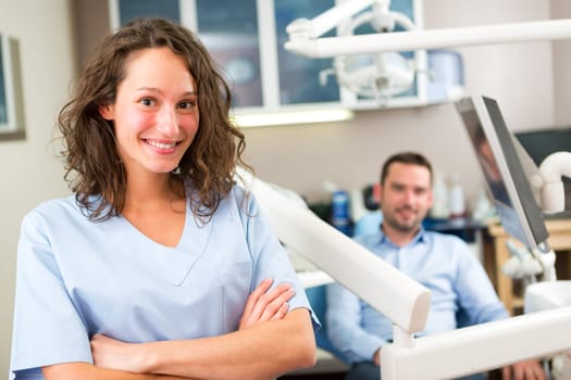 View of a young attractive dentist in his office