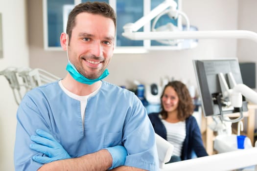 View of a young attractive dentist in his office
