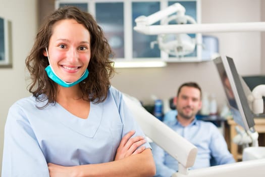 View of a young attractive dentist in his office