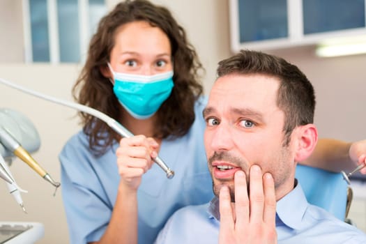 View of a Young attractive man scared to being cured by a dentist