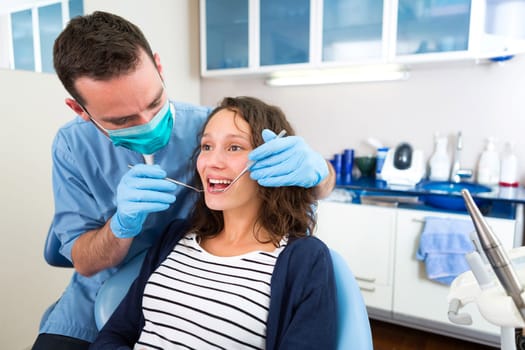 View of a Young attractive woman being cured by a dentist