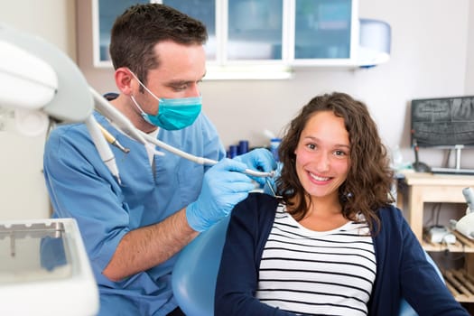 View of a Young attractive woman being cured by a dentist
