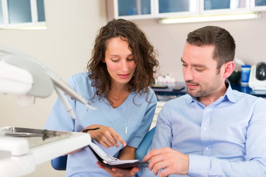 View of a Young attractive dentist programs next date