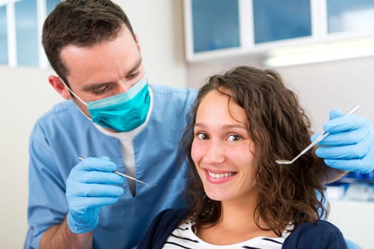 View of a Young attractive woman being cured by a dentist
