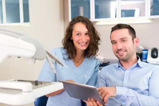 View of a Young attractive dentist explaning his work to a patient