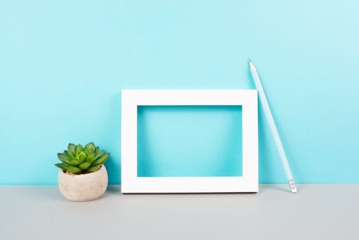 Home interior poster mock up with wooden frame, cactus in a pot, blue wall background, copy space for text and pictures