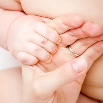 Infant holding mother's hand, shallow focus