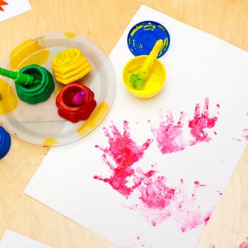White paper with child handprints on on a table