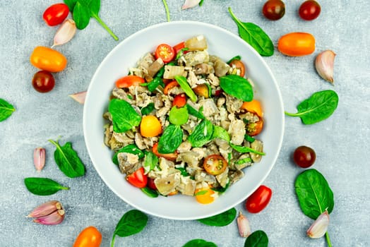 Tasty salad of baked eggplant, tomato and spinach.