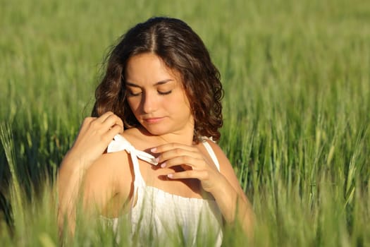 Woman tying dress lace in the mittle of a wheat field