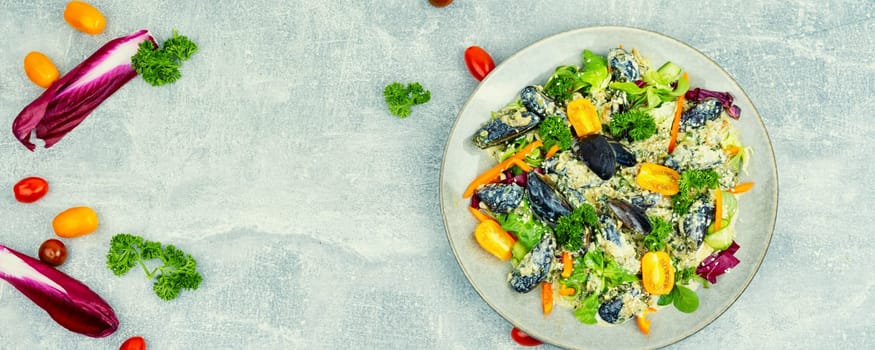 Plate with a salad of fresh vegetables, herbs and mussels.