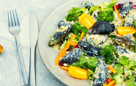 Plate with a salad of fresh vegetables, herbs and mussels.