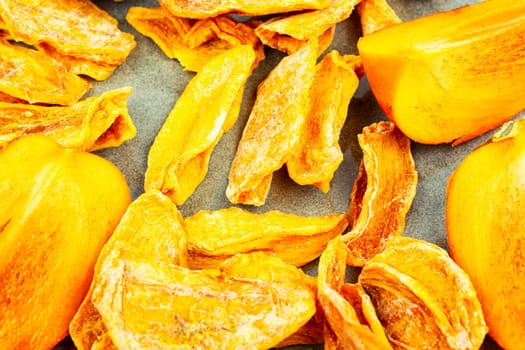 Sweet dried persimmon on the plate. Healthy vegan snacks. Copy space