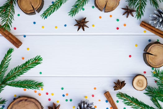 Green branches of a Christmas tree and confetti on a background of white boards. Flat lay. Copy space