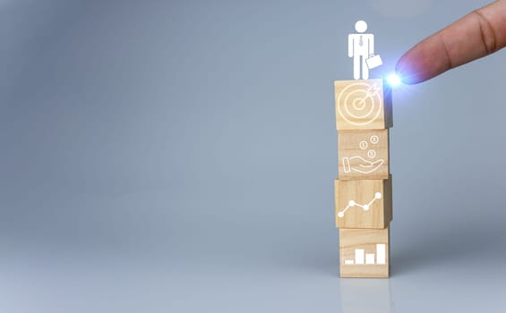 Hand pointing at one wood cube block with target icon . Concept of business strategy and goal action plan.