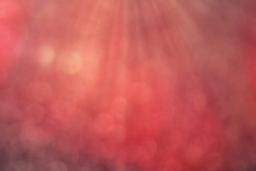 Red bokeh background with defocused round lights and sunbeams, flare overlay